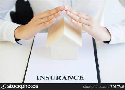 Female hands saving small house, Real estate business. insurance protection concept.