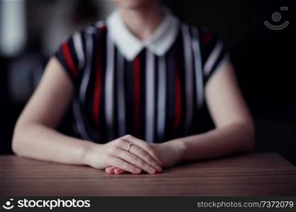 female hands sitting at the table waiting