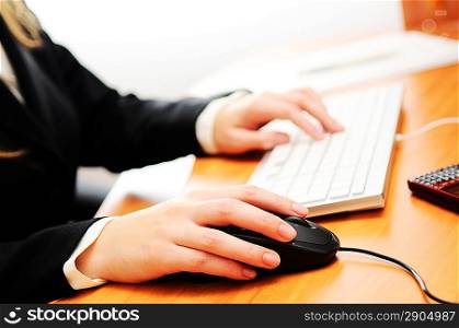 Female hands typing on a keyboard and holding mouse