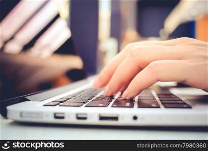 Female hands typing on keyboard of laptop &#xA;