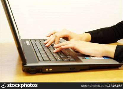 Female hands typing on laptop keyboard