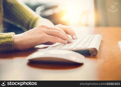 Female hands typing text on a wireless keyboard. Woman working on coputer concept.