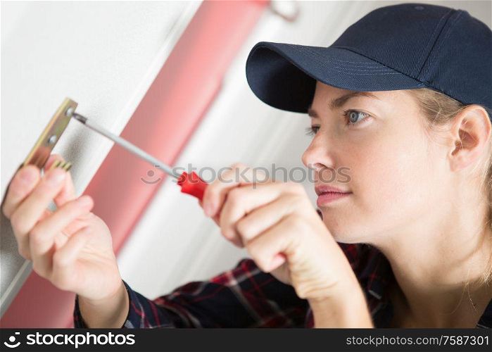 female handyman installing a hook on the wall