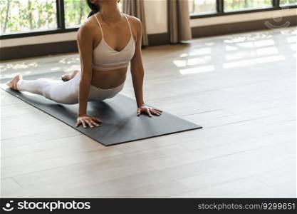 Female happiness Attractive young asian woman doing yoga stretching exercise on mat yoga & fitness exercises. Healthy lifestyle Calmness and relax at home