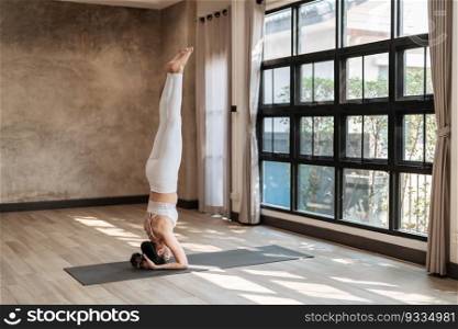 Female happiness Attractive young asian woman doing yoga stretching exercise on mat yoga   fitness exercises. Healthy lifestyle Calmness and relax at home
