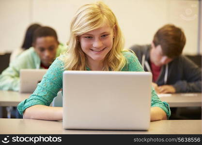 Female High School Student At Desk In Class Using Laptop