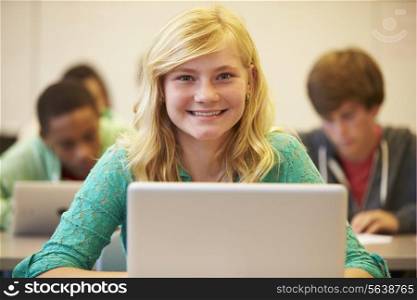 Female High School Student At Desk In Class Using Laptop