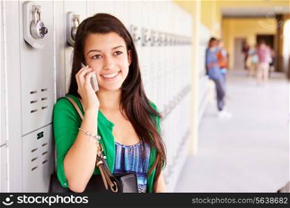 Female High School Student By Lockers Using Mobile Phone