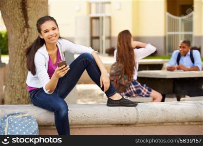 Female High School Student Using Phone On School Campus