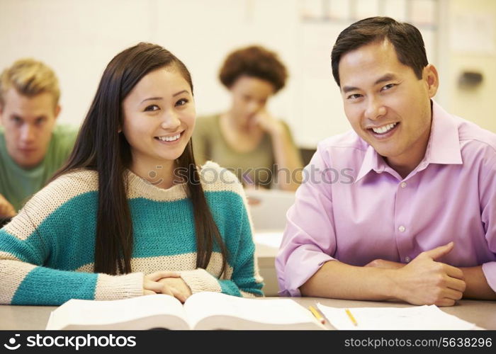 Female High School Student With Teacher Studying At Desk