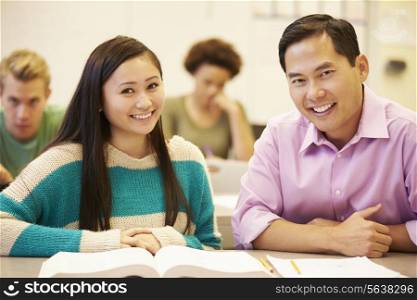 Female High School Student With Teacher Studying At Desk