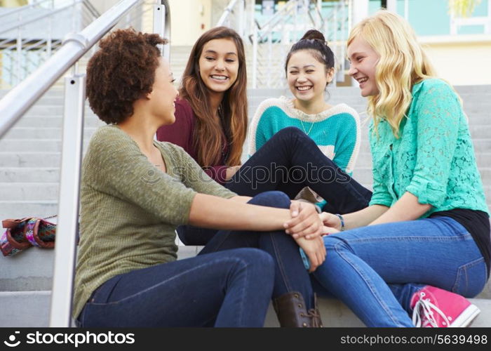 Female High School Students Sitting Outside Building