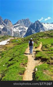 female hiker is walking on footpath in Contrin Valley, Trentino, Italy