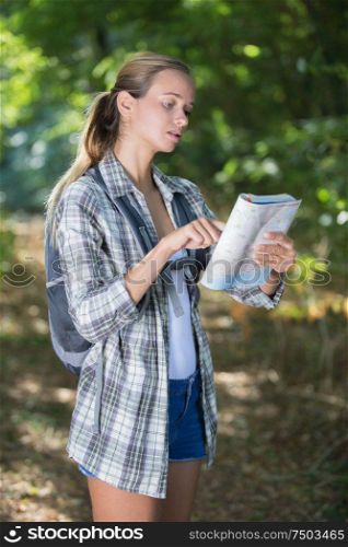 female hiker looking at map in forest