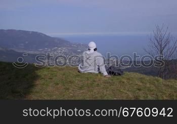 Female hiker resting on top of a mountain Ai-Petri enjoying the view. Yalta, Crimea, vertical dolly shot
