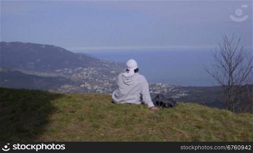 Female hiker resting on top of a mountain Ai-Petri enjoying the view. Yalta, Crimea, vertical dolly shot