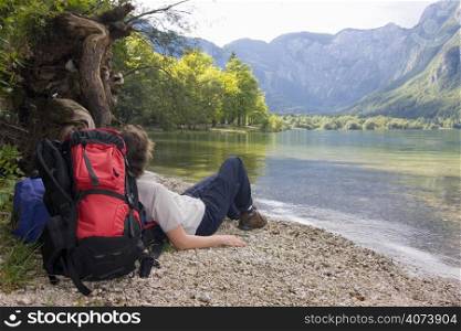 Female hiker with rucksack resting at a mountain lake