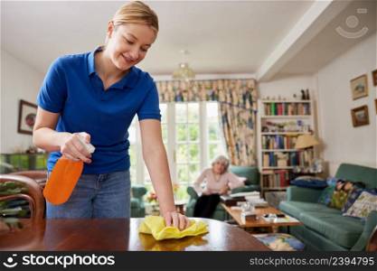 Female Home Help Cleaning House And Talking To Senior Woman