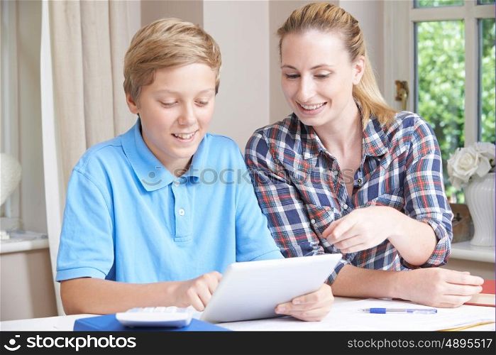Female Home Tutor Helping Boy With Studies Using Digital Tablet