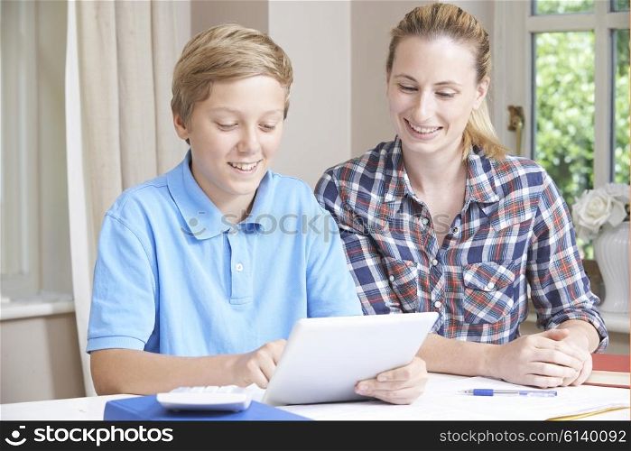 Female Home Tutor Helping Boy With Studies Using Digital Tablet