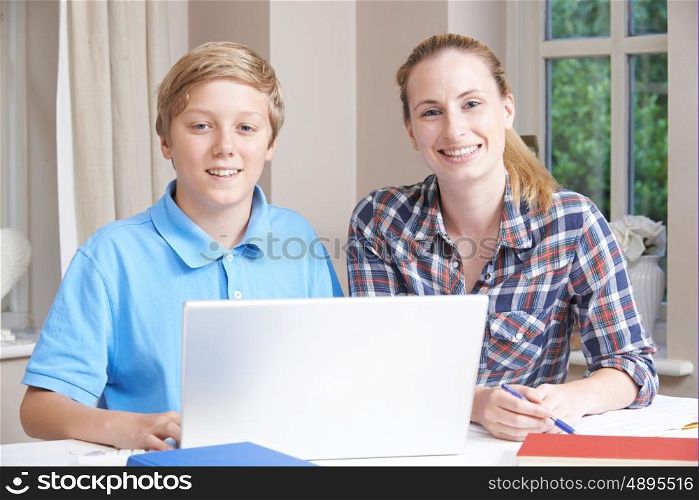 Female Home Tutor Helping Boy With Studies Using Laptop