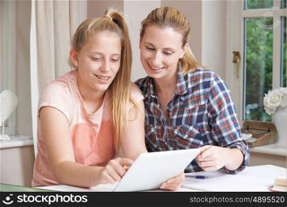 Female Home Tutor Helping Girl With Studies Using Digital Tablet