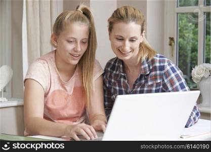 Female Home Tutor Helping Girl With Studies Using Laptop