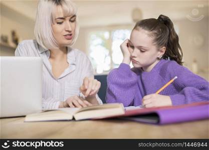 Female Home Tutor Helping Young Girl Struggling With Studies Or Home Schooling