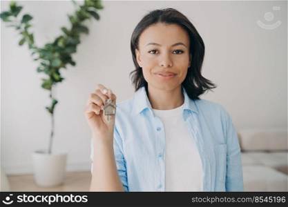 Female homeowner tenant showing key to rented or purchased new house. Woman real estate agent suggests apartment holding bunch of keys, standing in modern flat. House rental service, mortgage loan ad.. Female real estate agent offers keys to new home apartment. House rental service advertisement