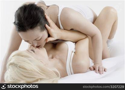 Female homosexual couple romancing on the bed
