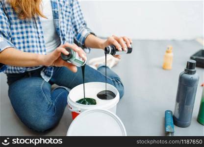 Female house painter mixes paints before painting. Home repair, happy woman doing appartment renovation, room decoration renovating. Female house painter mixes paints