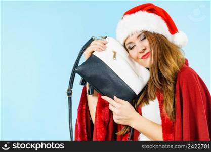 Female in santa claus clothing holding present handbag purse.. Christmas girl holding handbag present