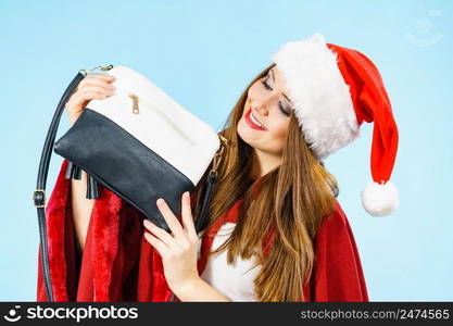 Female in santa claus clothing holding present handbag purse.. Christmas girl holding handbag present