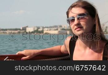 female in sunglasses looking overboard from the ship