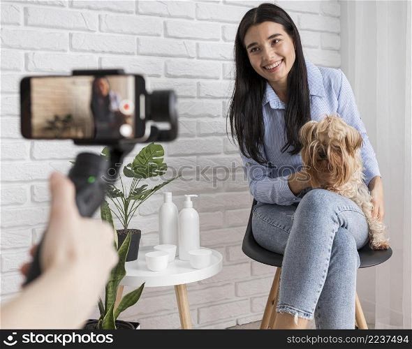 female influencer home with dog smartphone