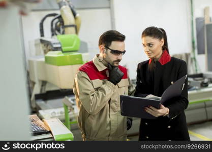 Female inspector and carpenter discuss the process of making wood products for furniture