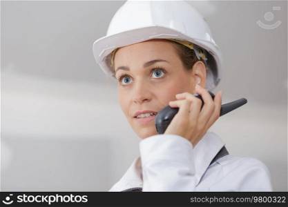 female inspector in helmet with walkie talkie