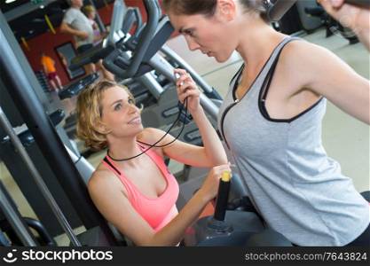 female instructor leads woman in the gym