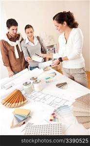 Female interior designer with two clients at office choosing colors