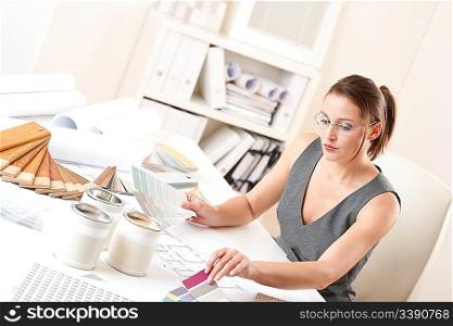 Female interior designer working at office with color swatch choosing color