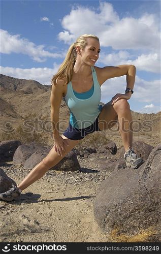 Female jogger stretching in mountains