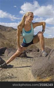 Female jogger stretching in mountains
