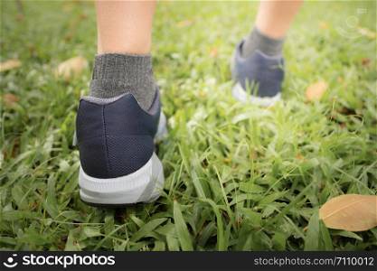 Female jogging in Central Park by wearing sports shoes exercise in the evening sunset.