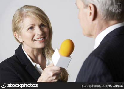 Female Journalist With Microphone Interviewing Businessman