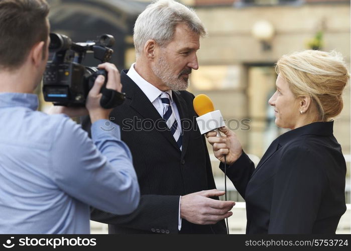 Female Journalist With Microphone Interviewing Businessman