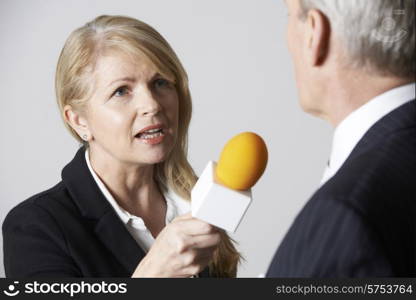 Female Journalist With Microphone Interviewing Businessman