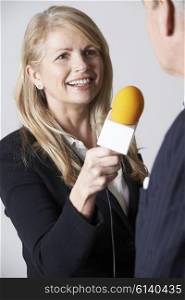 Female Journalist With Microphone Interviewing Businessman