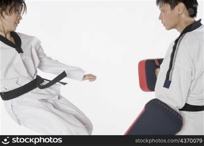 Female karate instructor teaching martial arts to a young man