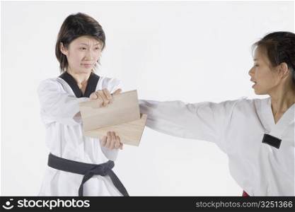 Female karate instructor teaching martial arts to a young woman