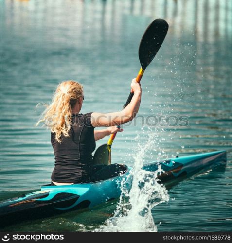 Female kayaker training on lake